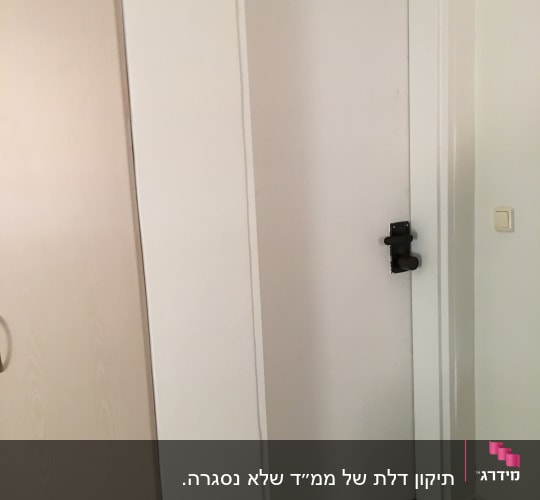 דלת לבנה עם מנעול בריח שחור